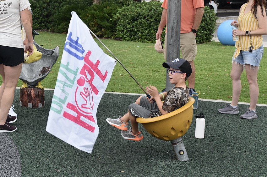 Seven-year-old Carson Mathis waves a flag before the walk.