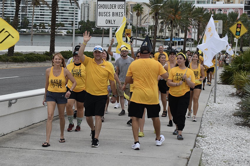 The group moves onto John Ringling Causeway with Dawn Grooms and President Shawn Platt in front.