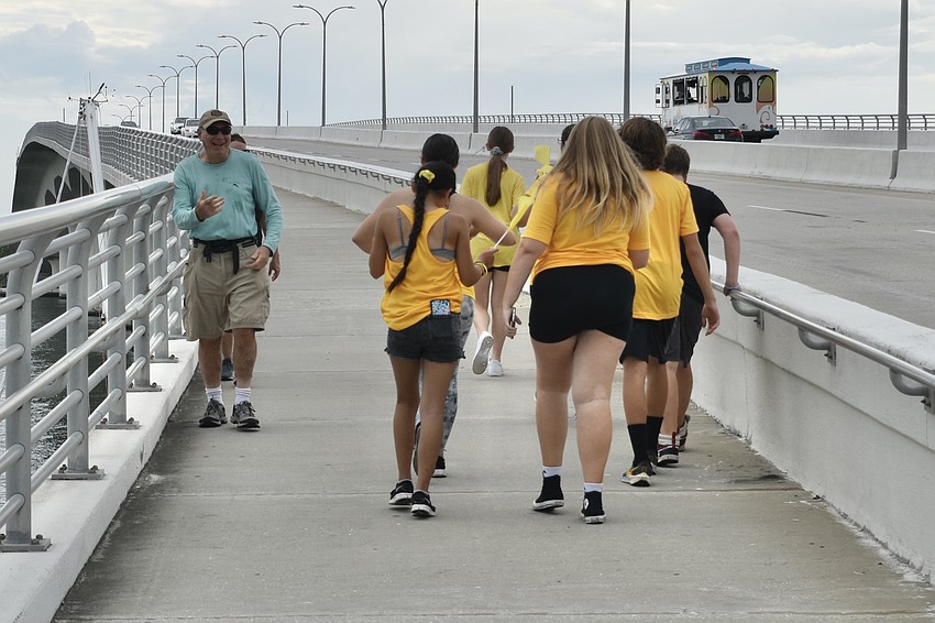 Mark Goldberg, walking on the bridge with his wife Sharon Goldberg, greets a group of walkers.