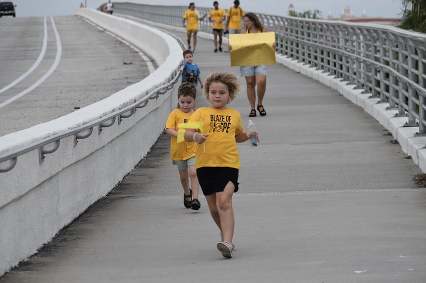 7-year-old Pyper Hutchinson and 4-year-old Griffin Hutchinson run along the bridge with 4-year-old Rory Hutchinson and Heather Hutchinson in back.