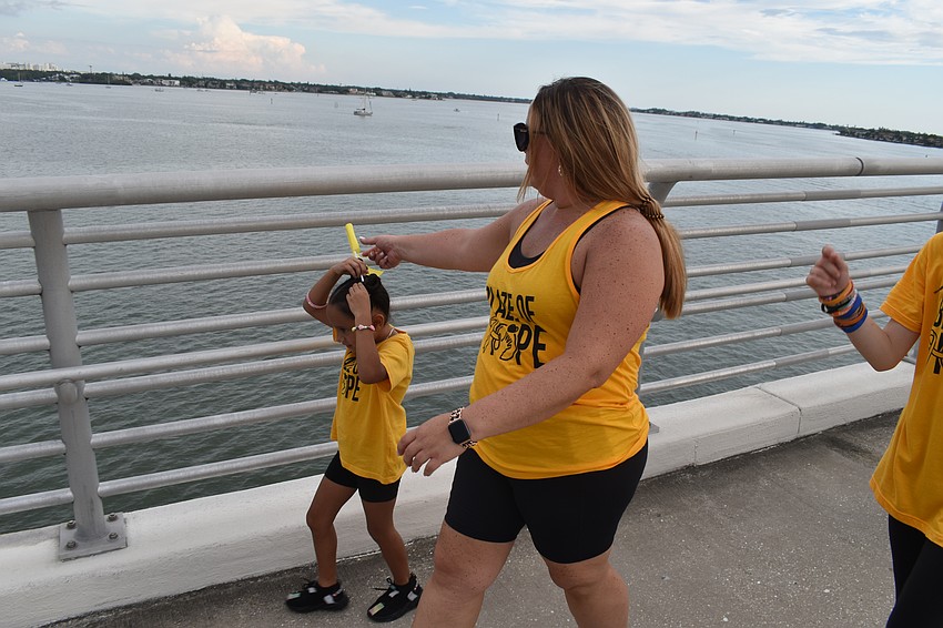 Seven-year-old Grace Miriles tries to place a flag in her hair with help from Meghan Houlihan.
