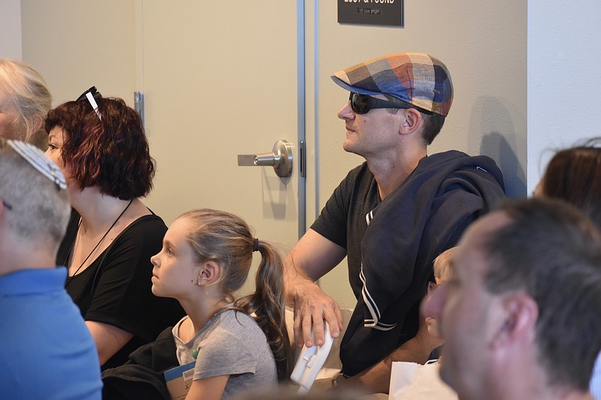 Ana Koro, 8, and Michael Koro watch the presentation on shofars by Rabbi Chaim Steinmetz.
