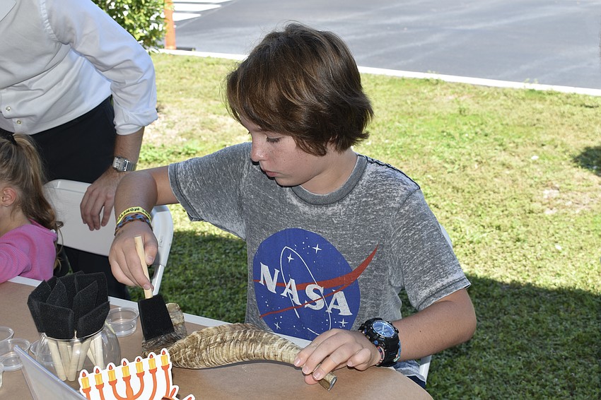 Spencer Cabana, 12, works on a shofar.