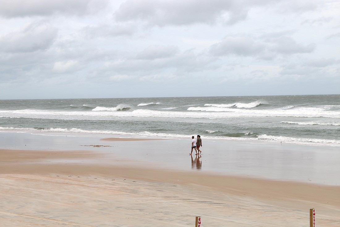 People walk on the beach in Ormond. File photo by Jarleene Almenas