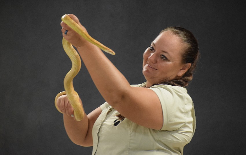 Sasha Kenyon, an educational outreach programmer for Big Cat Habitat, holds up a snake so students can see its skin color.