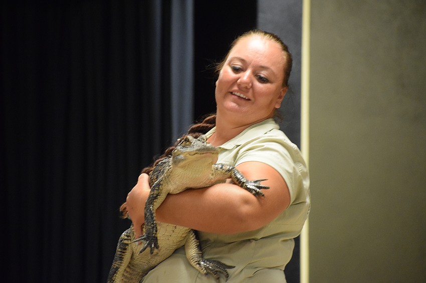 Sasha Kenyon, an educational outreach programmer with Big Cat Habitat, holds onto an American alligator for students to see. Students screamed as soon as she took the alligator out of its container.