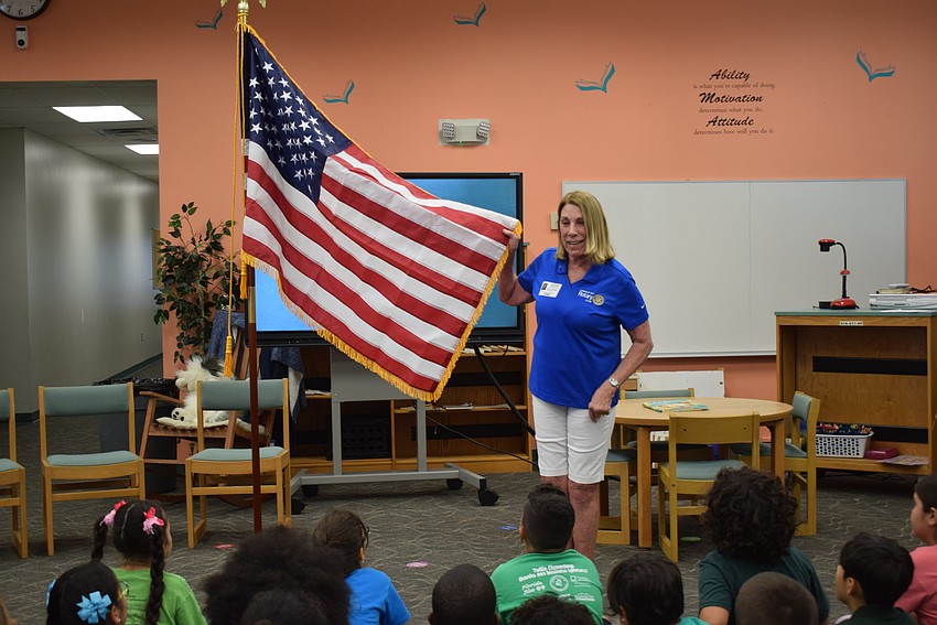 Nancy Rozance presenting the new American flag for the Media Center at Tuttle Elementary School