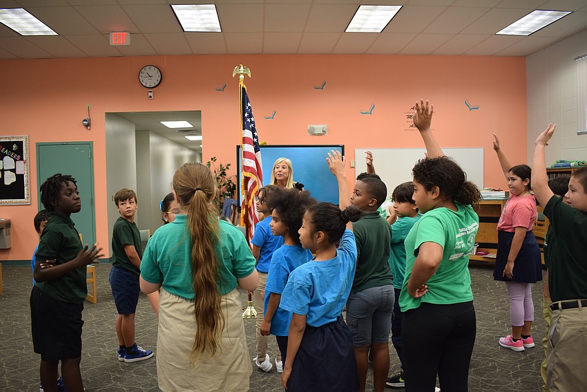 Prinicipal Patti Folino demonstrating the importance of the new American flag donated by the Rotary Club of Longboat Key to Tuttle Elementary School.
