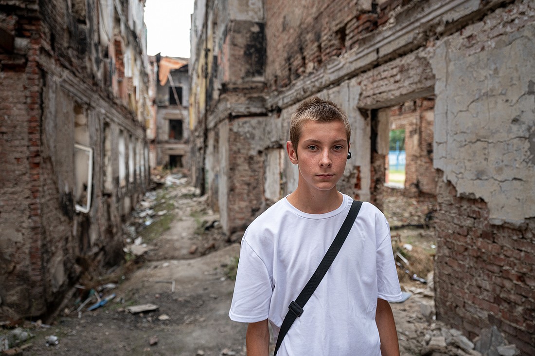 Slava, a Ukrainian student, stands in the rubble of his school that was destroyed in the Battle of Kharkiv.