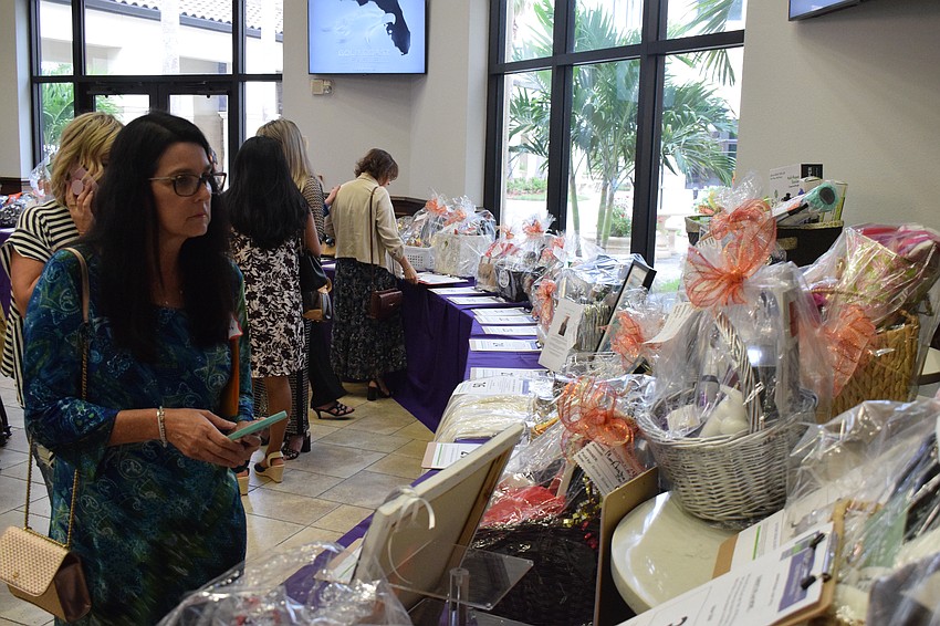 Osprey's Leslie Williams sees what the silent auction has to offer during her first Designer Bag Bingo.