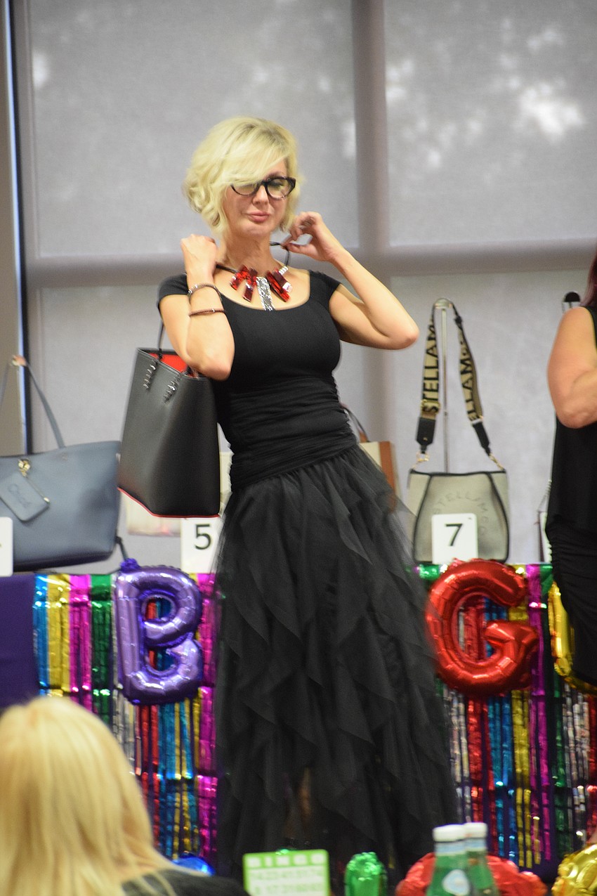 Lakewood Ranch's Karen Medford draws attention to the jewelry she's wearing while she models clothing from Darci Boutique.