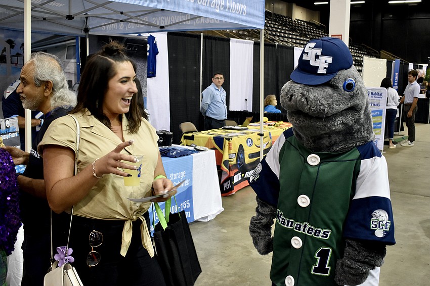 Nicole Miller, a Brandon-based employee of Grapevine Communications in Lakewood Ranch, meets  Maverick the Manatee, the State College of Florida mascot.