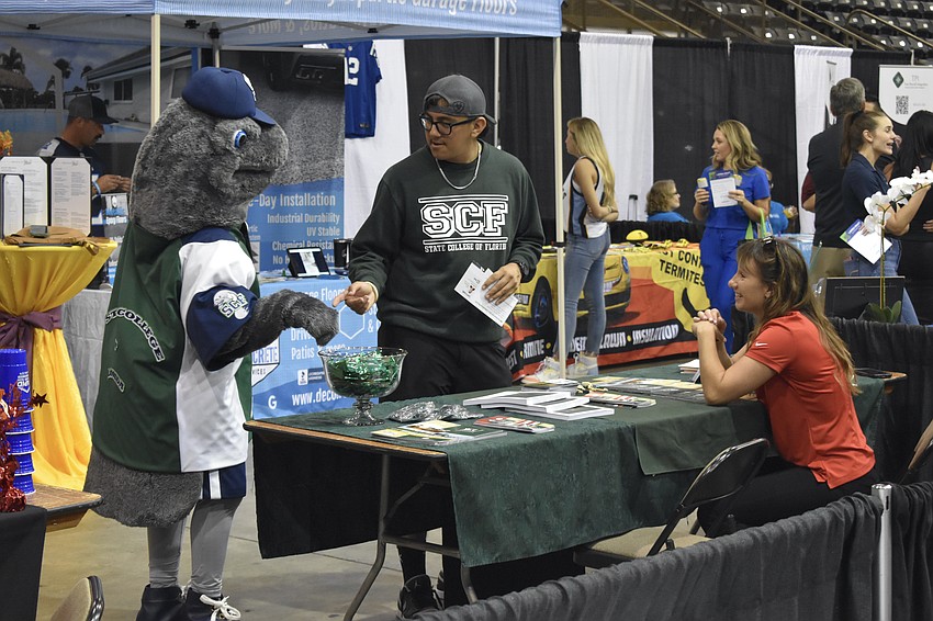 Maverick the Manatee and Bradenton's Alexander Martinez of State College of Florida speak with Sarasota's Sydney Pollock of Everglades University.