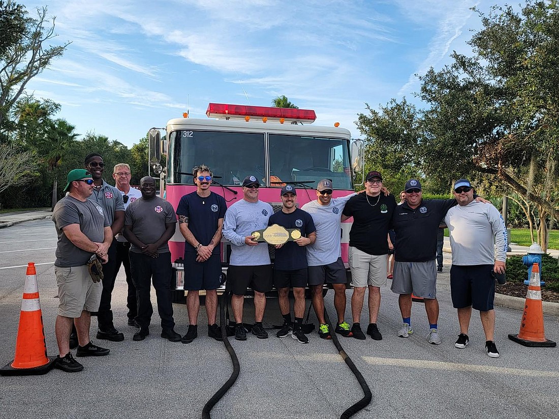 The Palm Coast Fire Department posing with the championship belt after the third annual Fire Truck Pull. Photo courtesy of the PCFD