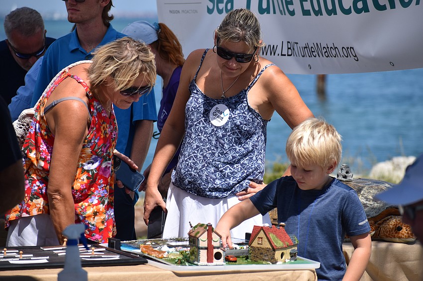Dana and Maggie Ryba, and Carter Ryba, 5, look explore a model demonstrating chemical pollutants at Longboat Key Turtle Watch.
