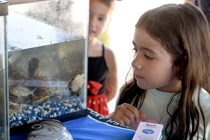Anaya Thompson, 5, and Sloane Hendricks, 6, explore the scene at the Fish and Wildlife Research Institute stand.