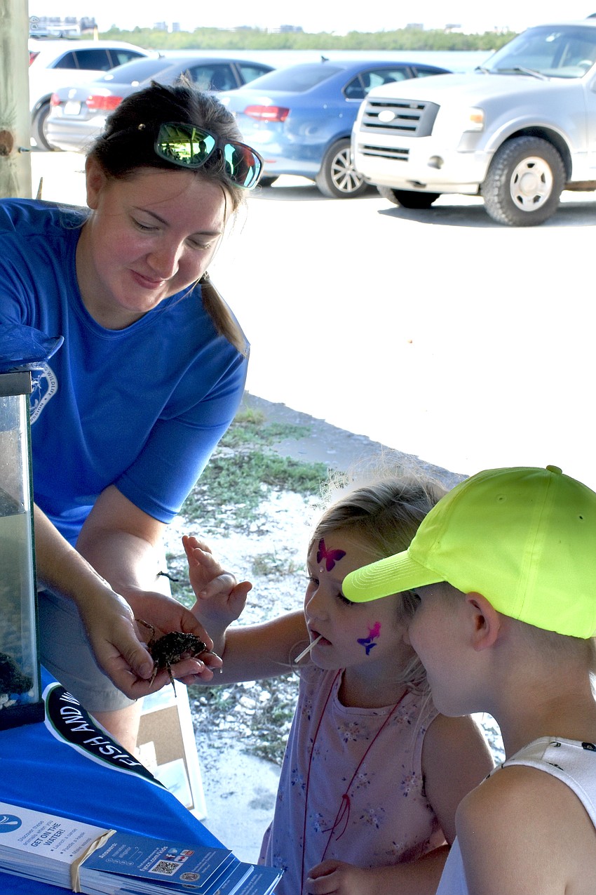 Natalie Munich of the Fish and Wildlife Research Institute showcases a spider crab to Illyana Recher, 5, and Zavier Recher, 8.