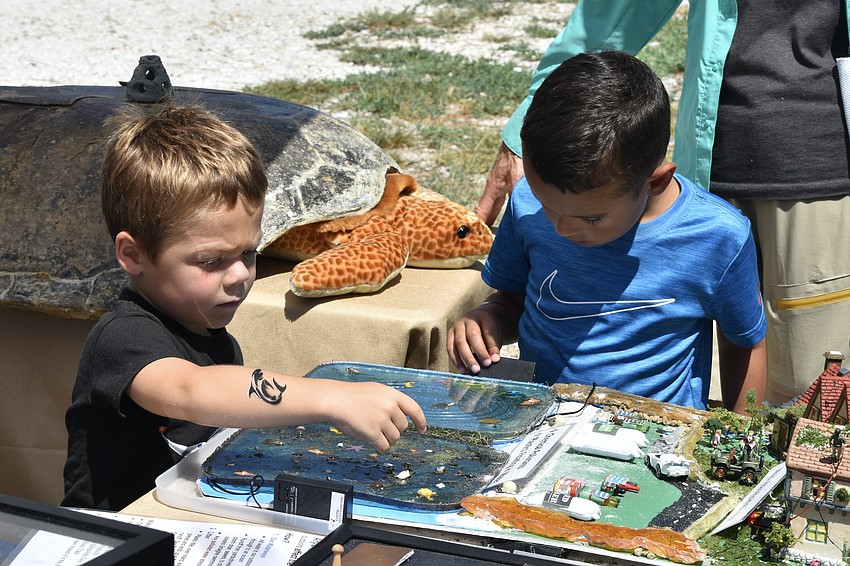 Robby Busick and James Strome, 5, explore a model demonstrating chemical pollutants at Longboat Key Turtle Watch.