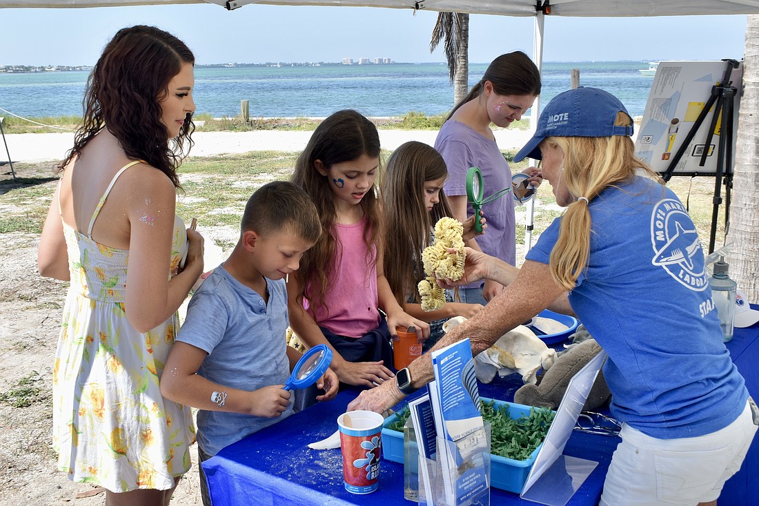 Ashley Smith, Leo Pecarina, 8, Scarlett Racki, 11, Felicity Racki, 8 and Joselyne Racki, 18, learn about different marine specimens from Kimberly Scaringe, education specialist at Mote Marine Laboratory & Aquarium.
