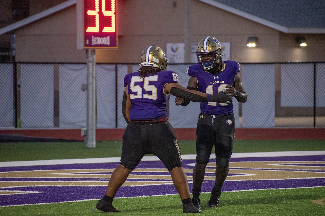 Booker junior Jordan Radkey (55) and sophomore Jason Thomas (16) celebrate after a tackle for loss.