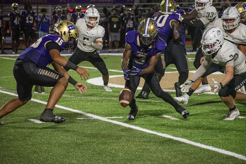 Booker High's Alex Diaz (15) and Rashawn Peterson (3) and Braden River High's Ronin Dangler (3) all dive for a loose football. Booker would keep possession.