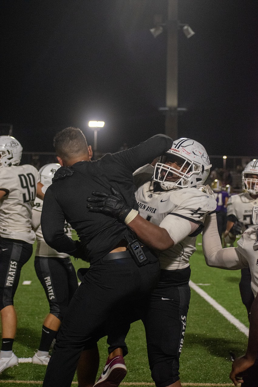Braden River High Head Coach Curt Bradley celebrates with his defense after a fumble recovery.