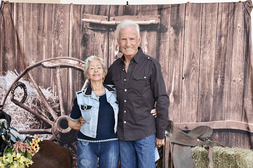 Jamille Romanet and Gerard Romanet stop by the photo area, which was set up with saddles and bales of hay.