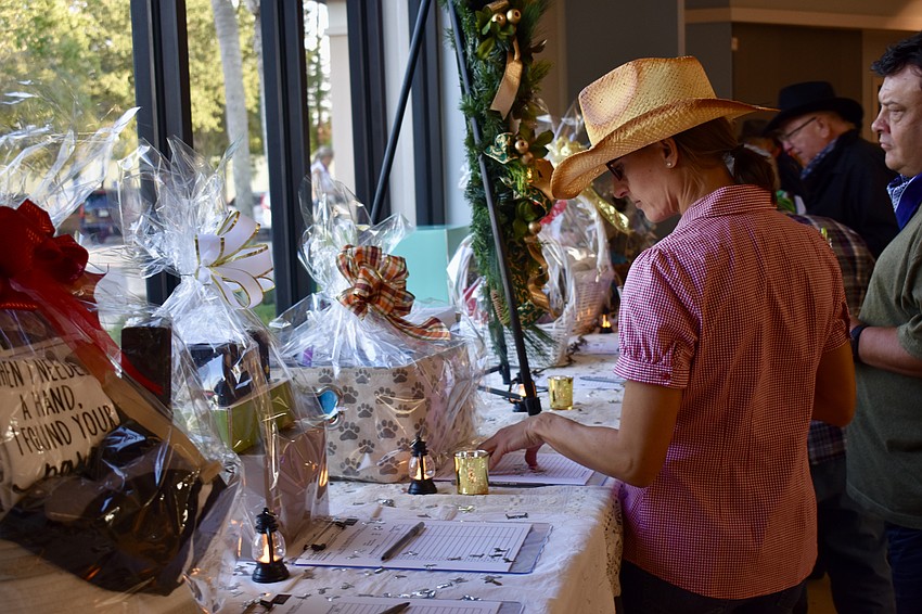 Venice resident and Catholic Charities employee, Helen Rombalski, checks out the auction items.
