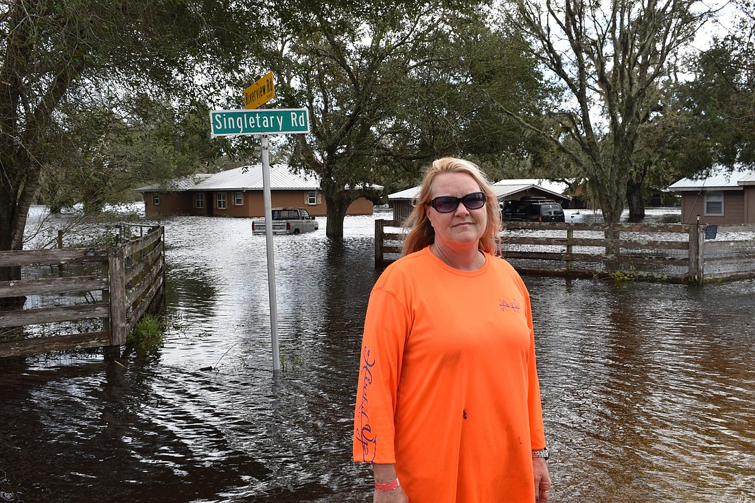 Veronica Young stands in front of her flooded home at Singletary Road and Riverview Road after Hurricane Ian devastates Myakka City.