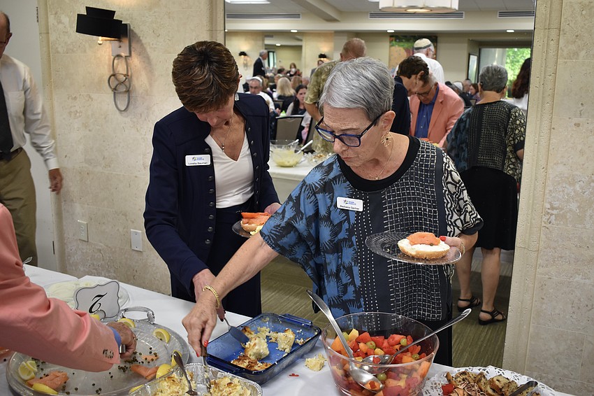 Loretta Bauman and Barbara Gerber gather their food as they break the fast.