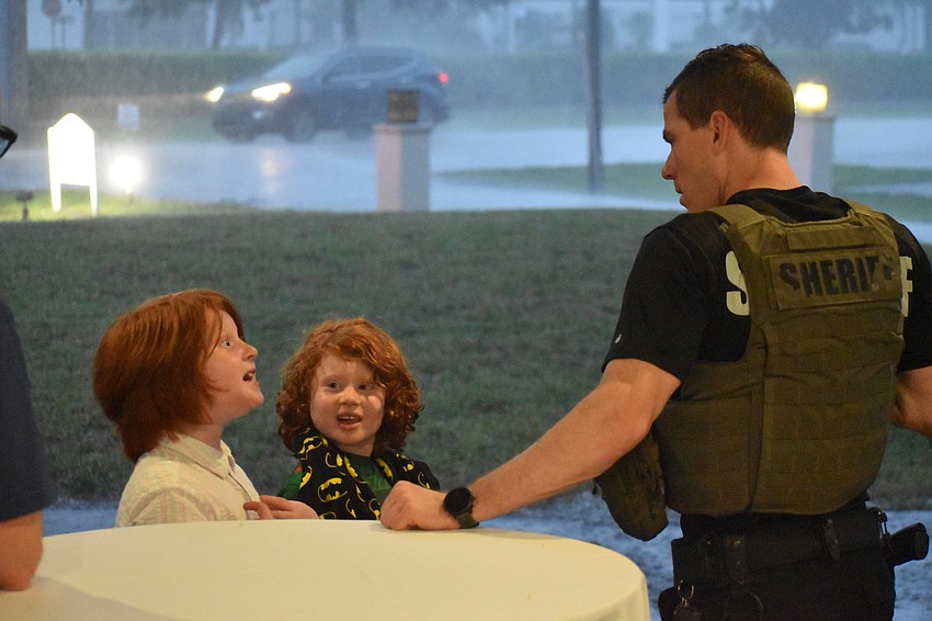 Joah Sigal-Verier, 8, and Avi Sigal-Verier, 5, talk with Officer Logan Mayer.