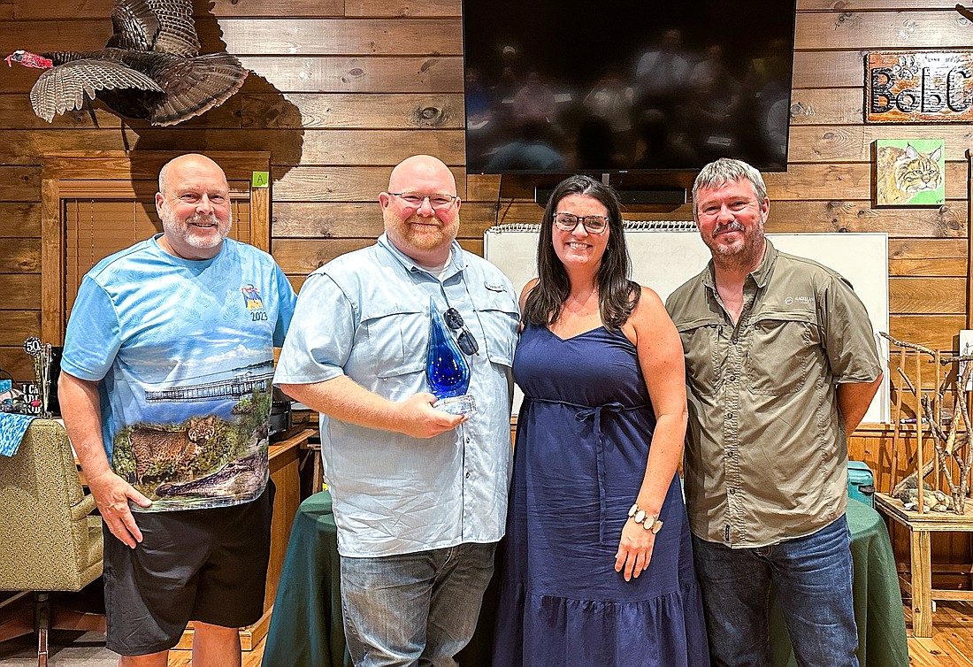 Adam Lovejoy, second from left, received the award from FOLA for his contribution to the restoration efforts in Lake Apopka. With him are FOLA Executive Director Joe Dunn; Adam’s wife, Jessica; and, FOLA President Steve Koontz.