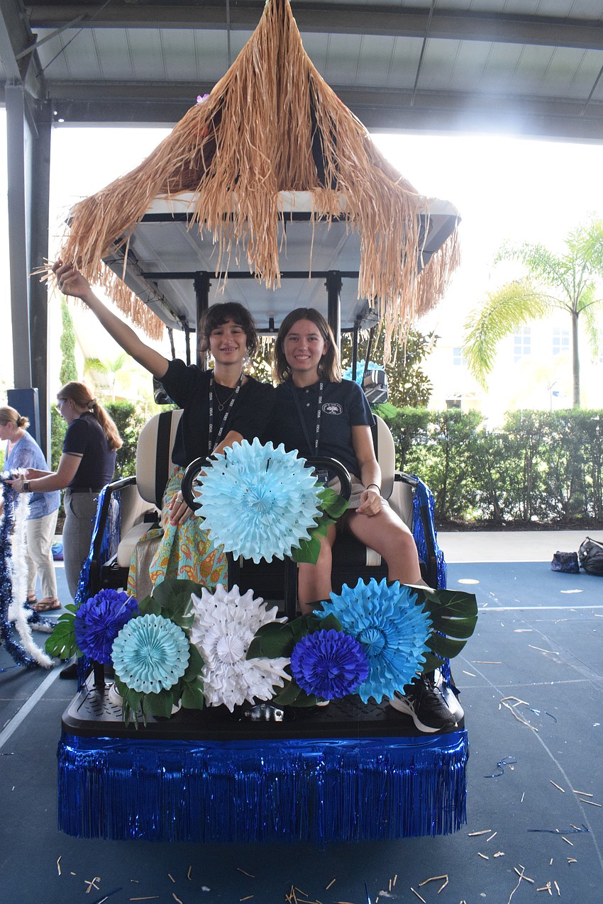 Eighth graders Sofie Roelens and Ellie Bysura decorate their golf cart with a tiki theme. 