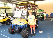 Sixth grader Ethan Burnstein loves how colorful the sixth grade peace themed golf cart is for the homecoming parade.