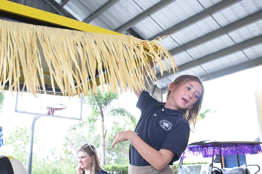 Fifth grader Maeve McAloon puts on the fringe that represents the Thunder Hut on the Siesta Key campus. The Thunder Hut is where students eat lunch.