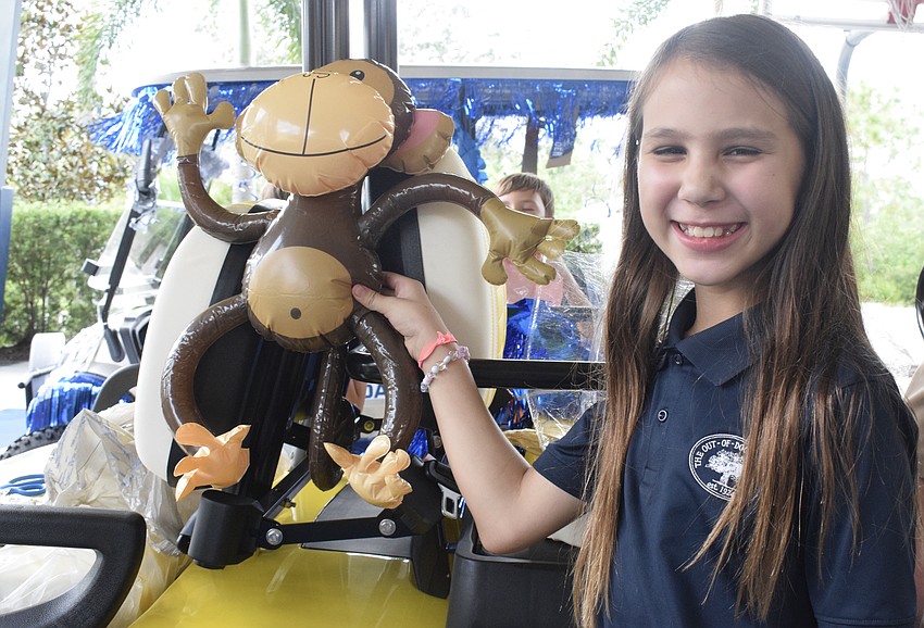 Fifth grader Laney Hildoer finds a spot for a monkey on the golf cart.