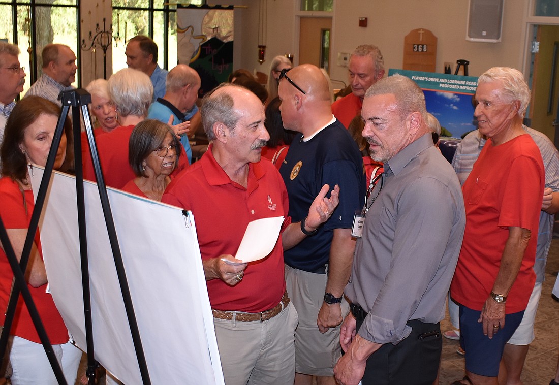 Mike Seifert, the president of the board for the Country Club East HOA, talks to District 5 Commissioner Ray Turner about the proposed roundabout. Seifert wants a signal light instead.