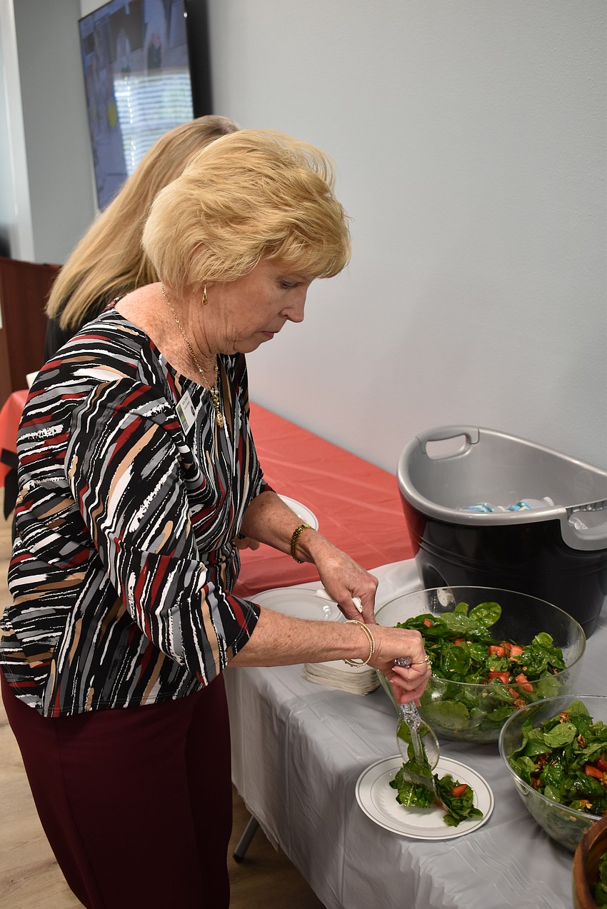 Kathy Collums digs into a salad during Cooking for Charity.