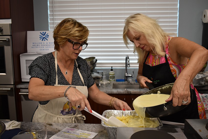 Angela Massaro-Fain stirs while Wanda Martinetto pours the Alfredo Sauce over the cheese tortellini.