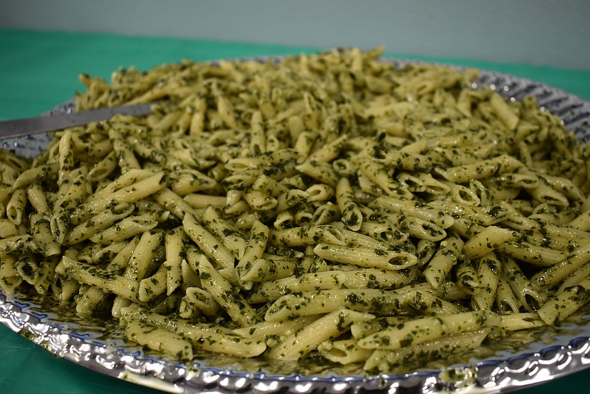 The crowd dug into a pile of pesto pasta.