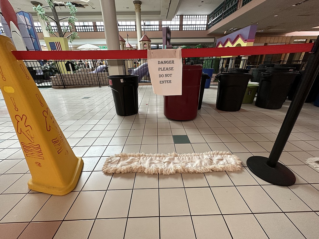 Trash cans to collect rainwater are blocked off from pedestrian traffic inside Regency Square Mall.