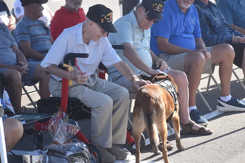 East County's John Skeen and Bob Pence pet the service dog Allie of the Canines for Heroes nonprofit.