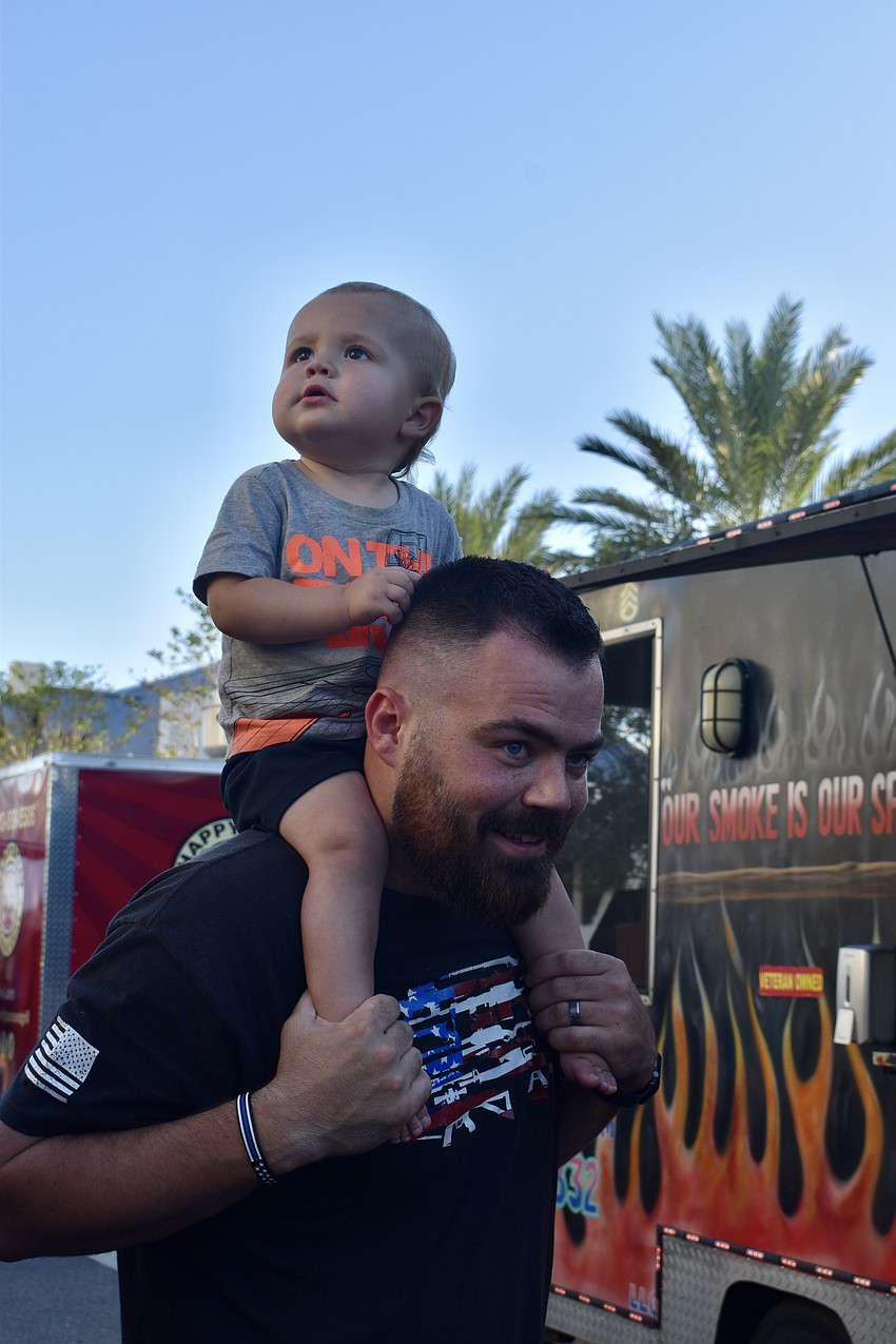 Max Paczesny watches the action from his dad Alex's shoulders. They're visiting Sarasota from Indiana for a week.