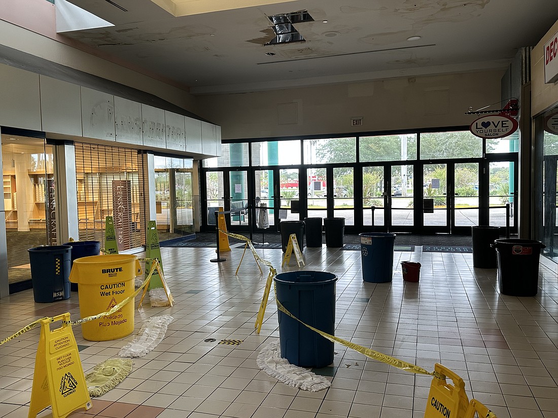 Customers entering Regency Square Mall must navigate past trash cans used to collect rainwater from the ceiling.