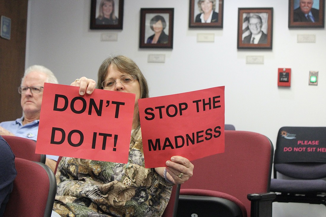 Melody Reedy is one of several Manatee County residents to hold up signs during the land use meeting Thursday in an attempt to stop commissioners from cutting wetland protections out of the Comprehensive Plan.