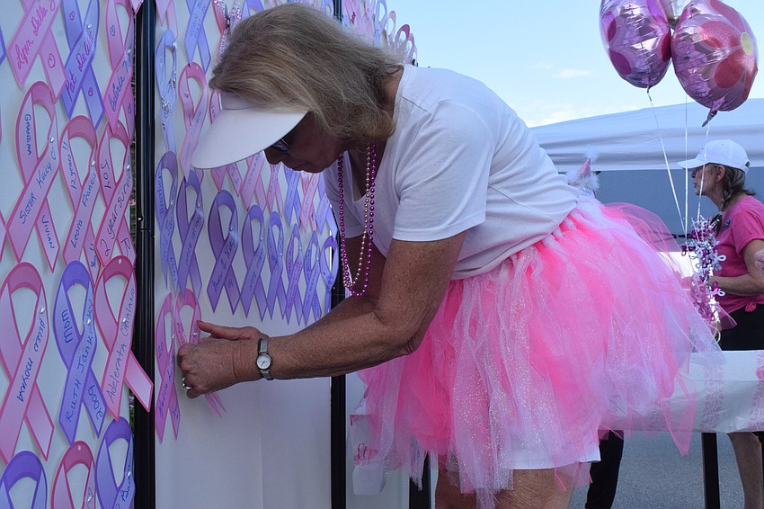 Del Webb's Gail Hedy pins a ribbon in honor of her friend and Del Webb resident Susan Mullins, who is recovering from a double mastectomy.