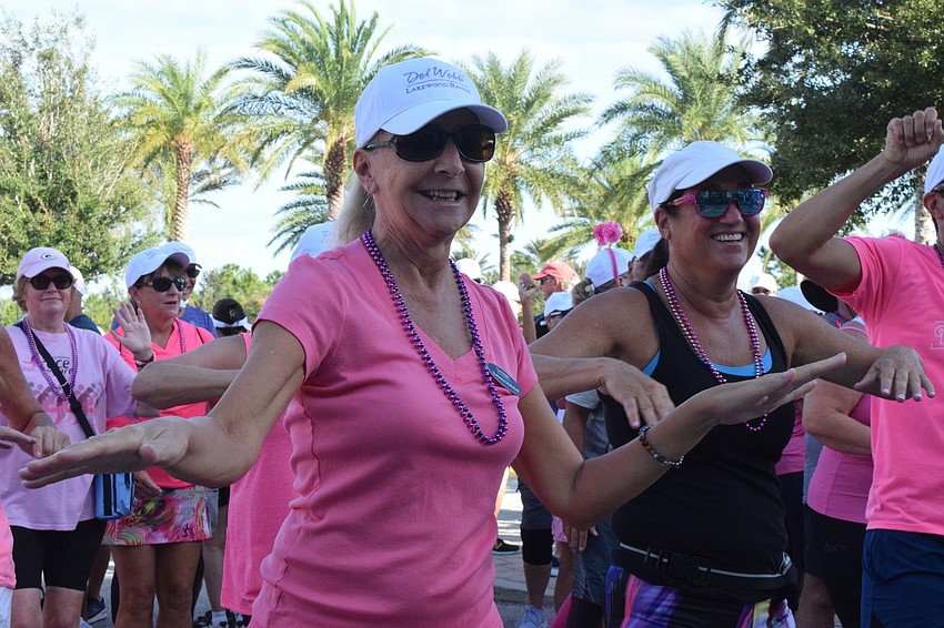 Del Webb's Roberta Mehrhof and Denise Cohen are on the move, dancing along to the music while warming up before the walk.