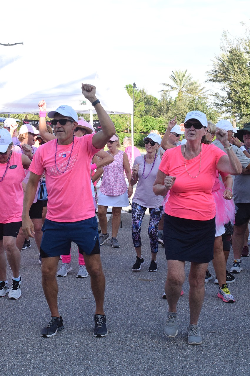 Del Webb's Roger Janczak and Cathy Janczak dance and groove along to the music to get pumped for the walk.