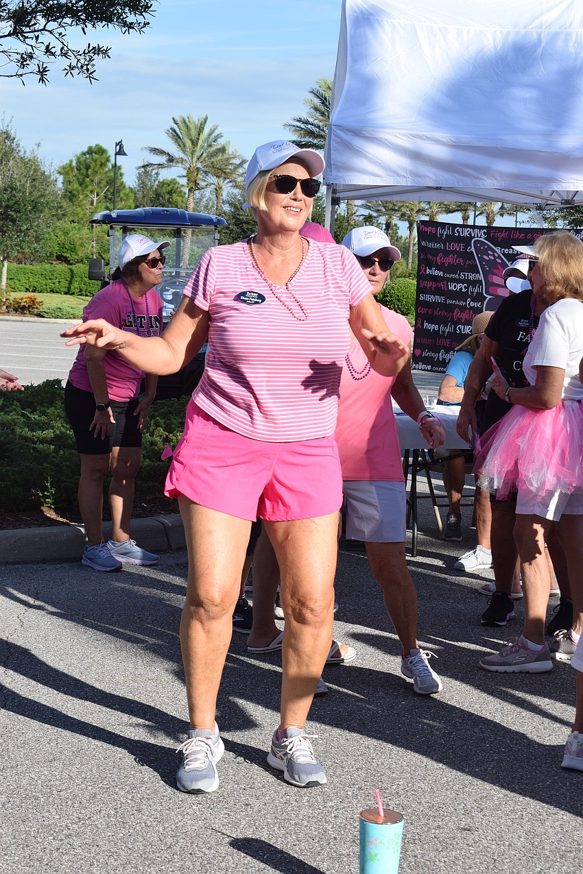 Del Webb's Diane Feinberg dances along to the warm-up before the walk.