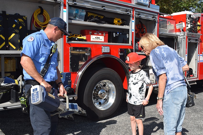 East Manatee Fire Rescue firefighter Jason Burnside shows Lakewood Ranch 8-year-old Ryan Martin and his grandmother Joyce Harpring how they use the jaws of life.